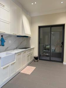 a kitchen with white cabinets and a woman in the background at Villa Amanda 3 - City Center- Private swimming Pool in Phan Thiet