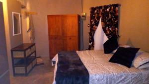 a bedroom with a bed and a dresser in it at Sabali in Rietfontein