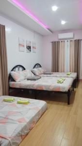 two beds in a room with pink lighting at Julia's Villa Bukidnon in Manolo Fortich +12 photos