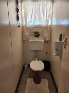 ein kleines Badezimmer mit Toilette und Fenster in der Unterkunft DE SWARTE MOSSEL in Hondeklipbaai + 11 Fotos