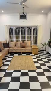 a living room with a couch on a checkered floor at Sooru in Mysuru in Mysore