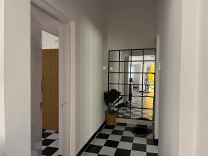 a hallway with a mirror and a black and white checkered floor at Sooru in Mysuru in Mysore