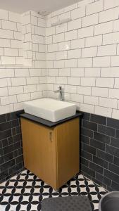 a bathroom with a sink and black and white tiles at Sooru in Mysuru in Mysore