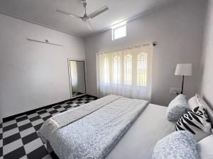 a bedroom with a bed and a checkered floor at Sooru in Mysuru in Mysore
