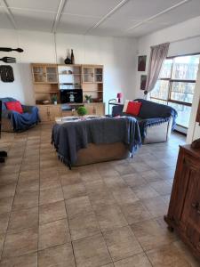 ein Wohnzimmer mit einem Bett und einer Couch in der Unterkunft DE SWARTE MOSSEL in Hondeklipbaai