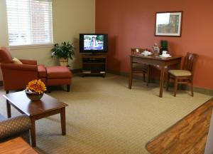 - un salon avec un canapé et une télévision dans l'établissement Affordable Suites of America Fredericksburg, à Fredericksburg