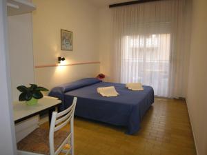1 dormitorio con cama, mesa y ventana en Hotel Garni Tahiti en Bibione