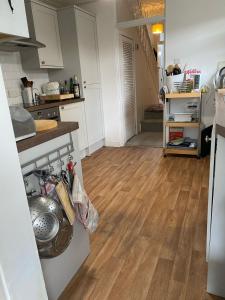 a kitchen with white cabinets and a wooden floor at Spacious 4-Bed Home R&B STAYS Welcomes You in Eastbourne