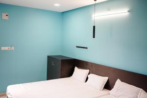 a bedroom with two beds and a blue wall at H2cottage in Wodapatti
