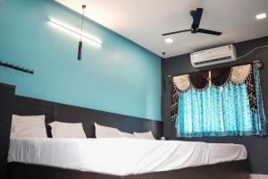 a bedroom with a large bed with a blue wall at H2cottage in Wodapatti