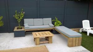 a patio with a bench and a table and a couch at Maison bord de mer 3 chambres in Les Sables-dʼOlonne