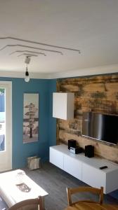 a living room with a white table and a tv at Maison bord de mer 3 chambres in Les Sables-dʼOlonne