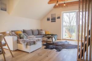 a living room with a couch and a large window at Nora Apartments in Dolní Morava