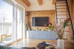 a living room with a tv on a wall at Nora Apartments in Dolní Morava