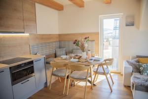 a kitchen and dining room with a table and chairs at Nora Apartments in Dolní Morava