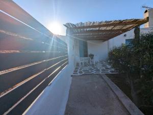 un patio con mesa y sillas bajo una pérgola en Oasis apartment with sea view, en Alopronia