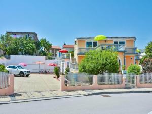 a building with umbrellas and a car parked in a parking lot at Apartment in Croatia near the Adriatic Coast in Senj +2 photos