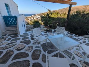 Dos sillas y una mesa en un patio de piedra. en Oasis apartment with sea view, en Alopronia