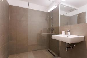 a bathroom with a sink and a mirror at Central Modern Studio Apartment with Free Parking in Vienna