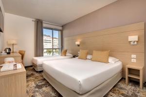 Una cama o camas en una habitación de Hôtel Le Méditerranée