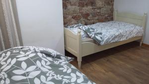 a bedroom with two beds and a brick wall at loft appartement dans bastide in La Celle-sous-Gouzon +3 photos