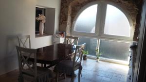 a dining room with a table and chairs and a window at loft appartement dans bastide in La Celle-sous-Gouzon