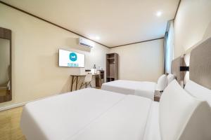 Una habitación de hotel con dos camas y un televisor de pantalla plana. en Hanting Shanghai Jufeng Road Subway Station Branch, en Shanghái 6 fotos más