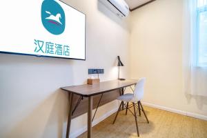 Un escritorio en una habitación con una silla blanca. en Hanting Shanghai Jufeng Road Subway Station Branch, en Shanghái