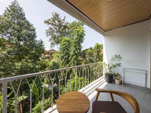 un balcone con tavolo, sedie e alberi di Tenkangin Homestay ad Ubud Altre 16 foto