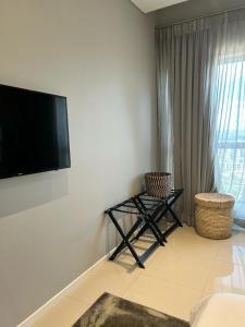 a living room with a flat screen tv on the wall at Itowers Luxury Apartment in Gaborone