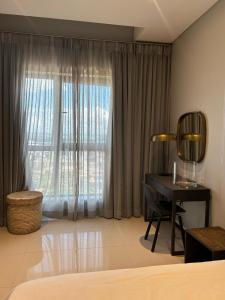 a bedroom with a desk and a window at Itowers Luxury Apartment in Gaborone