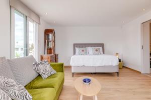 a living room with a bed and a green couch at Delimare, Acropolis & Sea View Rooftop, Paleo Faliro in Athens