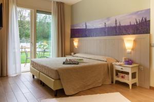 a bedroom with a bed and a large window at Agriturismo Ai Prati in Lazise