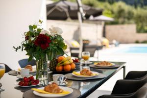 a table with plates of food and a vase of flowers at Villa Casa de Flores in Dubravka