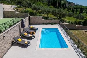 a swimming pool with lounge chairs and an umbrella at Villa Casa de Flores in Dubravka