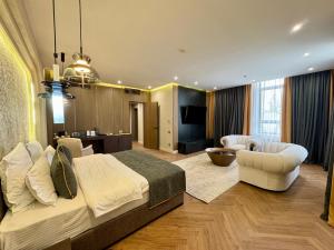Un dormitorio con una cama grande y una sala de estar. en Donatello Boutique Hotel, en Almaty