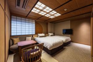 a bedroom with a large bed and a couch at Kyoto Ryokan SAKANOUE in Kyoto