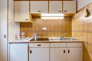 a kitchen with white cabinets and a sink at Mittermüllerhof Feldthurns in Velturno +59 photos