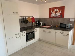 a kitchen with white cabinets and a stove top oven at Apartment Renate Strohhöfer in Hirschaid
