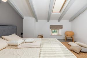 a bedroom with a large bed and a chair at Villa Jona in Žužići +49 photos