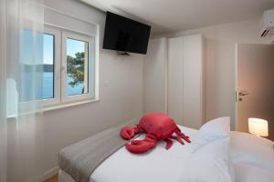 a stuffed red teddy bear sitting on a bed at Duka & Piko apartmani 1 in Lastovo