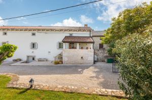an exterior view of a white house with a courtyard at Villa Jona in Žužići