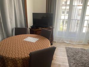 a room with a table and a television and a table and chairs at Appartement spacieux cosy centre Epinal !!! in Épinal