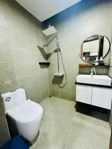 a bathroom with a toilet and a sink and a mirror at Kim's House in Thôn Lại Thê