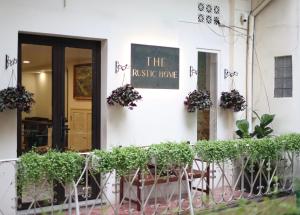 un bâtiment blanc avec des plantes devant lui dans l'établissement The Rustic Home - Room 2, à Hô-Chi-Minh-Ville