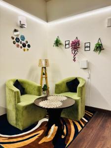 un soggiorno con due sedie e un tavolo di Elevated living luxury apartment with Mountain view a Dehradun