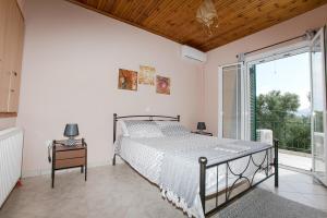 ein Schlafzimmer mit einem Bett und einem großen Fenster in der Unterkunft Evaggelatos Cottage in Lixouri