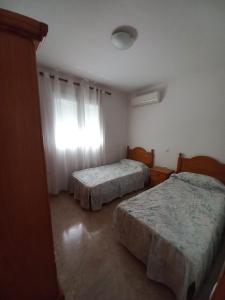 a bedroom with two beds and a window at Apartamento Villaricos con parking in Villaricos