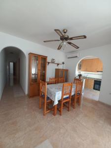 a dining room with a table and chairs and a ceiling fan at Apartamento Villaricos con parking in Villaricos