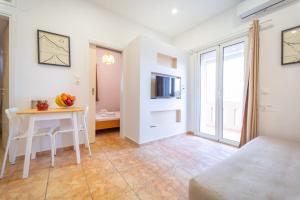 a living room with a table and a television in a room at Beachfront Cozy Apartments in Amoudara Herakliou